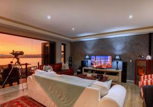 a living room with a couch and a television at Yadah Guest House in Mossel Bay