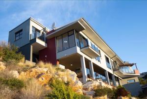 a house on top of a hill with rocks at Yadah Guest House in Mossel Bay