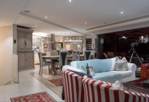 a living room with a couch and a dining room at Yadah Guest House in Mossel Bay