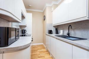 a kitchen with white cabinets and stainless steel appliances at No1 Coppergate - Donnini Apartments in Prestwick