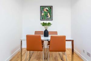 a dining room table with chairs and a vase of flowers at No1 Coppergate - Donnini Apartments in Prestwick +26 photos