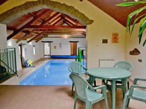 a pool room with a table and chairs and a table and a pool at Whortleberry Cottage in Wheddon Cross