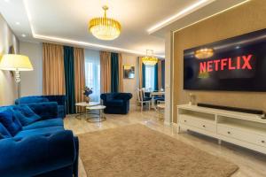 a living room with a television and blue furniture at Complex Rediu 54-PentHouse in Rediu