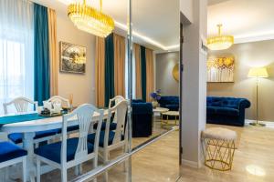 a dining room and living room with a blue table and chairs at Complex Rediu 54-PentHouse in Rediu