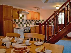 a kitchen with a table with food on it at Whortleberry Cottage in Wheddon Cross +3 photos