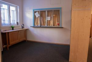 an empty room with a window and a desk at juhui Arosa in Arosa