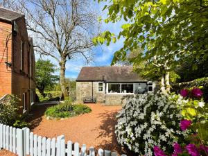 a white picket fence in front of a house at Craigrannoch Cottage in Rockcliffe +19 photos