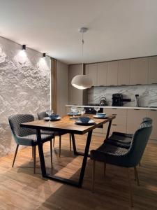 a kitchen with a wooden table and chairs at Stone & Soul House in Chernihiv