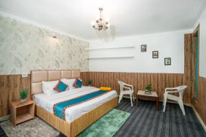 a bedroom with a bed and a table and chairs at Havana stays in Shoja +4 photos