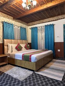 a bedroom with a large bed with blue curtains at Havana stays in Shoja