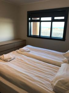 a large white bed with a window in a bedroom at Fell Holiday Home in Stapi