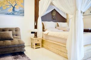 a bedroom with a canopy bed and a chair at Inaya Private Pool Villa in Ambat +43 photos