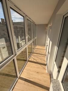 a room with windows and a hallway with wooden floors at JAVA ESTATE apartment in Rēzekne
