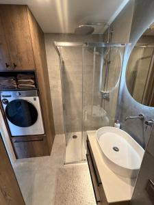 a bathroom with a sink and a washing machine at JAVA ESTATE apartment in Rēzekne
