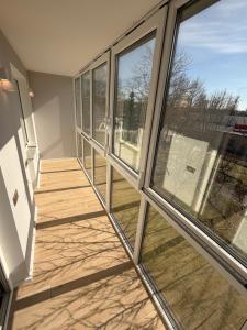 a balcony with glass windows and a wooden floor at JAVA ESTATE apartment in Rēzekne +4 photos