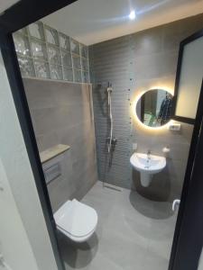 a bathroom with a toilet and a sink and a mirror at Location Appartement luxe in Mahdia +7 photos