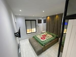 a bedroom with a bed with a green blanket at Location Appartement luxe in Mahdia