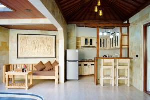 a kitchen with a couch and a refrigerator in a room at Inaya Private Pool Villa in Ambat