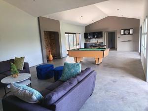 a living room with couches and a pool table at Tee Off House - Parys Golf and Country Estate in Parys