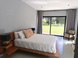 a bedroom with a bed and a large window at Tee Off House - Parys Golf and Country Estate in Parys +35 photos