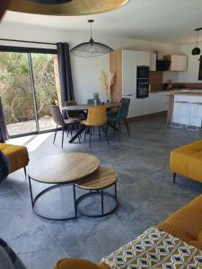 a living room with a table and chairs at Villa Cocooning, Piscine privative à Figari in Figari