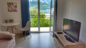 a living room with a large flat screen tv on a table at Apartmani Cupic in Budva