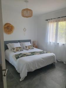 a bedroom with a large white bed with pillows at Villa Cocooning, Piscine privative à Figari in Figari