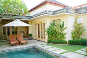 a villa with a swimming pool in front of a house at Inaya Private Pool Villa in Ambat