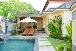 a pool in the backyard of a house with chairs and an umbrella at Inaya Private Pool Villa in Ambat
