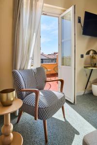 a living room with a chair and a balcony at Estoril Boutique Hotel - Adults Only in Estoril