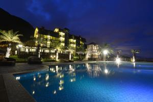 a resort with a swimming pool at night at Stuart Villa in Yanliau