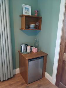 a kitchen with a wooden shelf and a dishwasher at Mountain hideaway in Finny