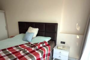 a bedroom with a bed with a blanket and a night stand at Modern, Pool with slide,150m to beach in Alanya +9 photos