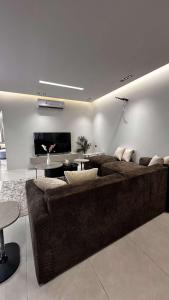 a living room with a brown couch and a table at شاليه بيرلا in Jeddah