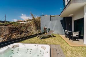 a jacuzzi tub on the patio of a house at GuestReady - Stay with stunning views in Santa Cruz +30 photos