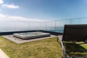 a chair and a tub on a balcony with the ocean at GuestReady - Stay with stunning views in Santa Cruz