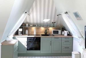 a kitchen with green cabinets and a stove at Haus Anholt in Timmendorfer Strand
