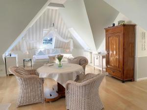 a living room with a table with chairs and a couch at Haus Anholt in Timmendorfer Strand