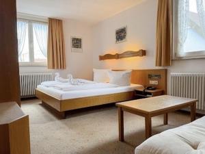 a hotel room with two beds and a table at Hotel Restaurant Bären in Weingarten