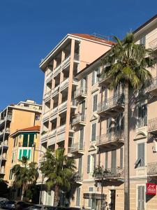 a tall building with palm trees in front of it at Casa Giardino Vista Mare in Ventimiglia
