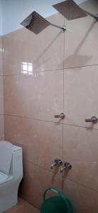 ein Badezimmer mit Glasdusche und WC in der Unterkunft Tharavad Homestay Athirappilly in Athirappilly