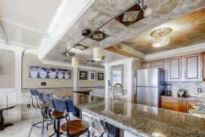 a kitchen with a granite counter top and a refrigerator at Pelican Beach Resort 1502 in Destin