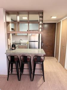 a kitchen with a table and two stools at Ivan Suite More than accommodation an experience in Santiago