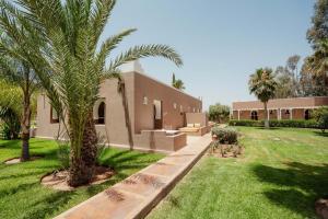 a house with a palm tree in the yard at DOMAINE DU DOUAR in Marrakesh