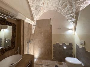 a bathroom with a toilet and a sink and a mirror at Opera Prima - Luxury Homes in Ceglie Messapica