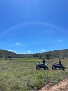 a couple of people riding motorcycles in a field at Bush Lovers Lodge in Modimolle