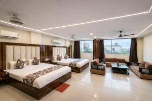 a hotel room with two beds and a couch at Hotel Shivdev International, near New Delhi Railway Station & City Centre in New Delhi