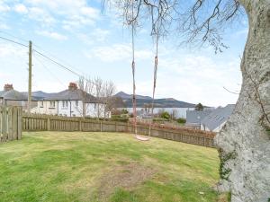 a swing in a yard next to a fence at Springbank in Brodick