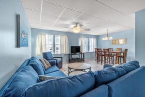 a living room with a blue couch and a table at The Treehouse On the Bay in Pensacola Beach