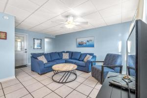 a living room with a blue couch and chairs at The Treehouse On the Bay in Pensacola Beach